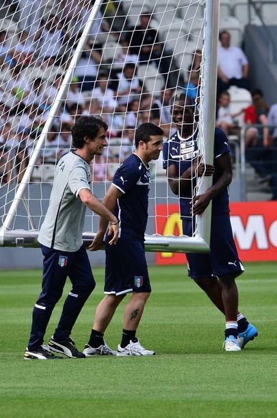 Tiền đạo Antonio Di Natale và trợ lý HLV Gabriele Pin vất vả khiêng cầu môn ra sân tập, Mario Balotelli lại bám vào và cười đùa.